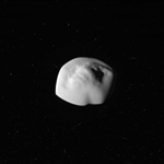 فضاپیمای کاسینی قمر اطلس کیوان را که در حال نزدیک شدن، و به شکل بشقاب پرنده است، رصد کرد